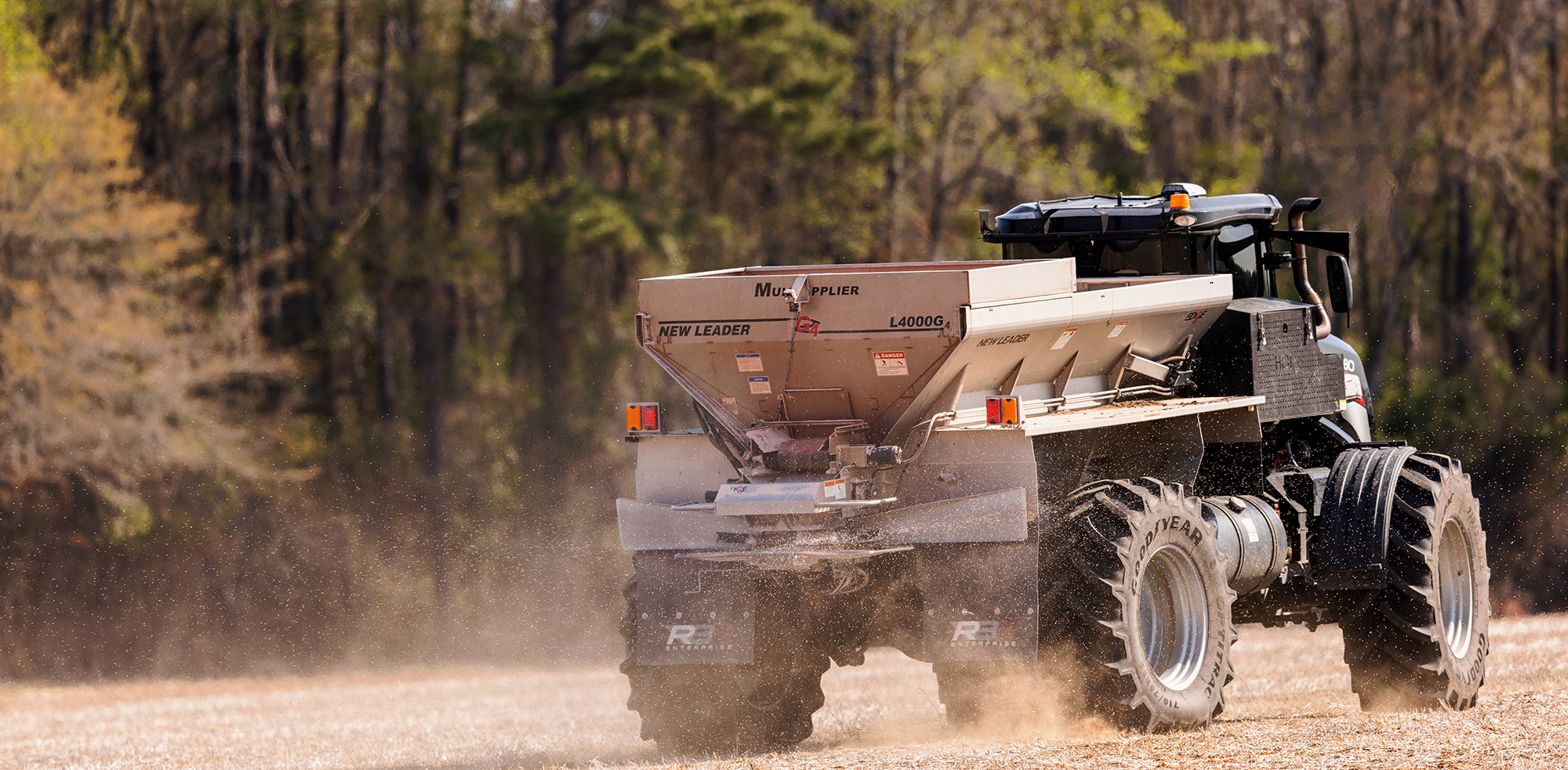 Spreader applying Wolf Trax coated urea to a field